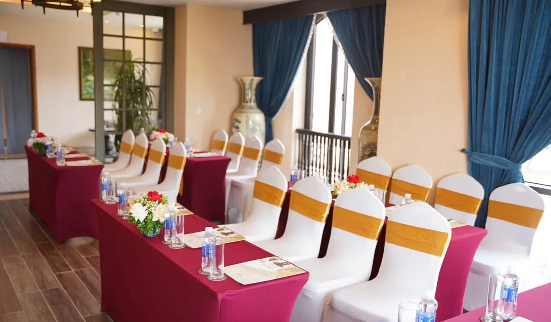 Phòng Function Venus Hotel Tam Đảo xếp bàn họp, cửa vòm, rèm xanh – Venus Hotel Tam Đảo